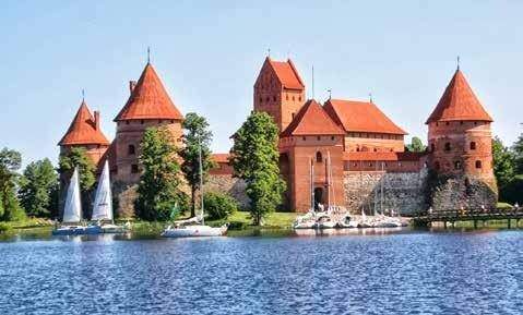 Wasserburg Trakai: Die Burg befindet sich auf einer Insel zwischen dem Galvė-See, dem Luka-See und dem Totoriškės-See. Eine Brücke führt vom Ufer zum Torhaus, das in die äußere Befestigungsmauer mit Wehrgängen und drei wuchtigen runden Ecktürmen eingebaut ist.